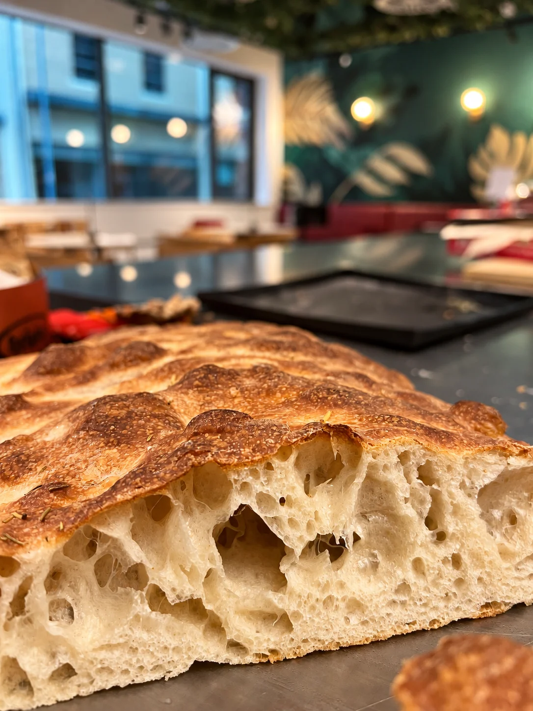Golden focaccia with an open, airy crumb on the counter at FORK café.